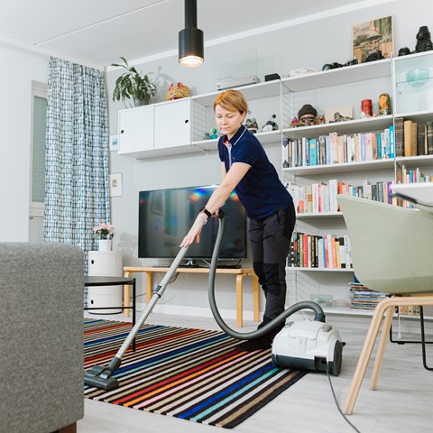 Kotisiivooja imuroi olohuoneessa